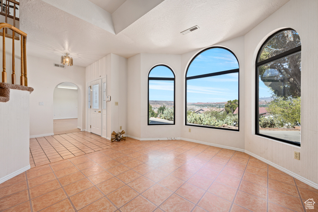 Entrance foyer with a textured ceiling and light tile patterned flooring