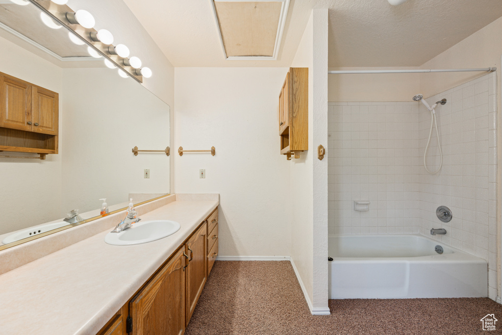 Bathroom featuring vanity and tiled shower / bath