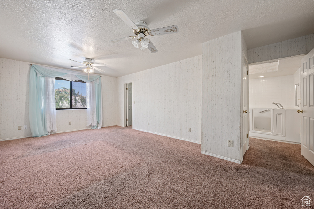 Carpeted spare room with a textured ceiling and ceiling fan