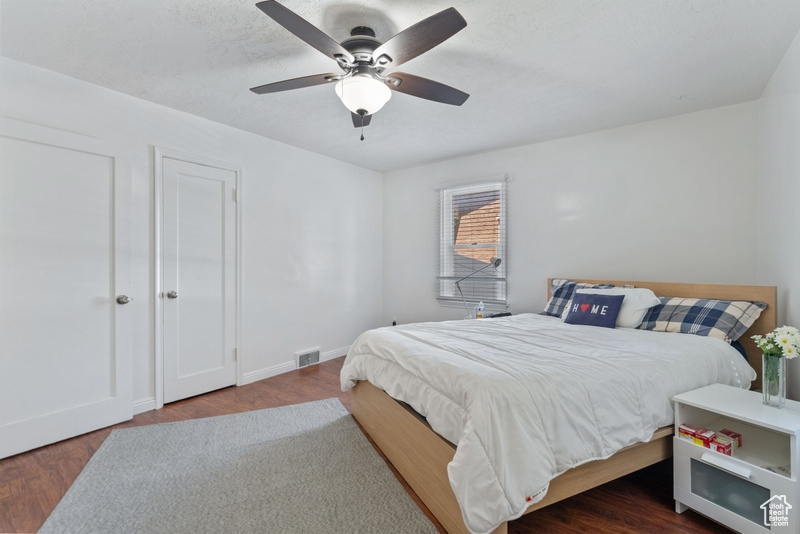 Bedroom with dark hardwood / wood-style floors and ceiling fan