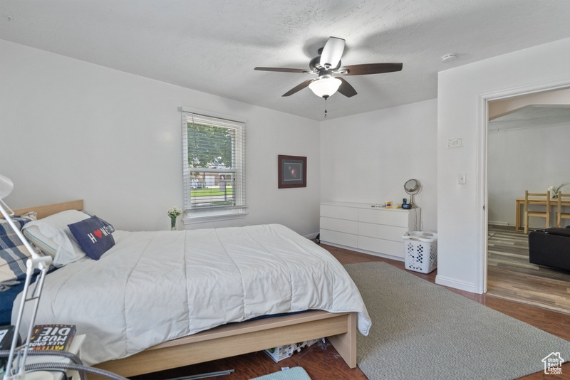 Bedroom featuring ceiling fan, a textured ceiling, and dark hardwood / wood-style flooring