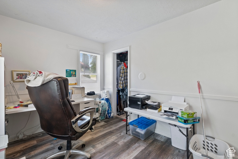 Office space with dark hardwood / wood-style flooring