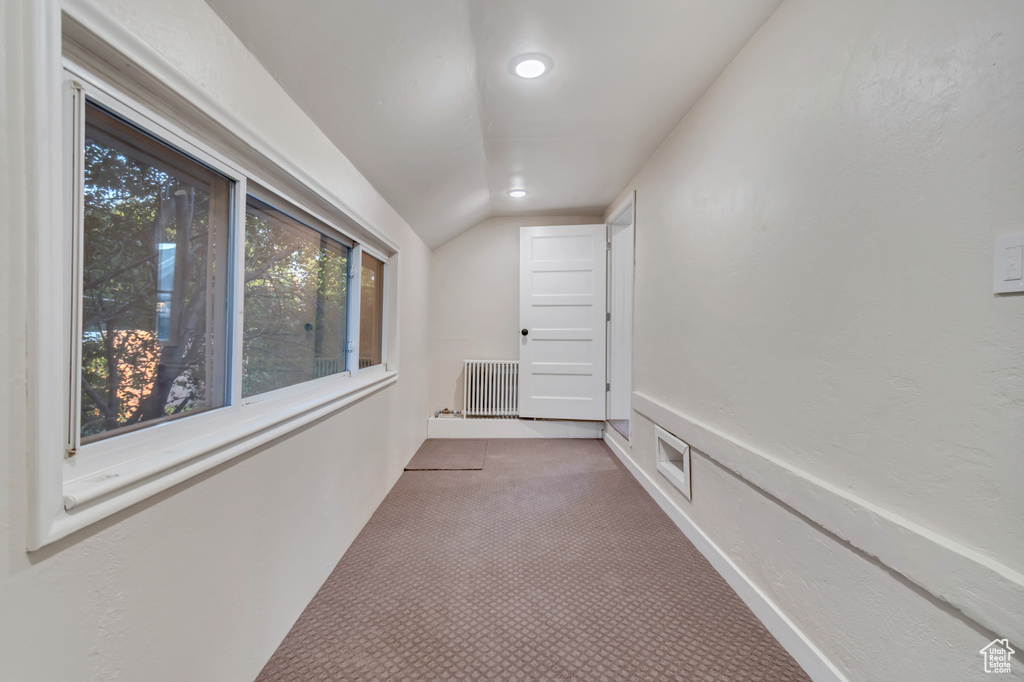 Hall featuring carpet, lofted ceiling, and radiator