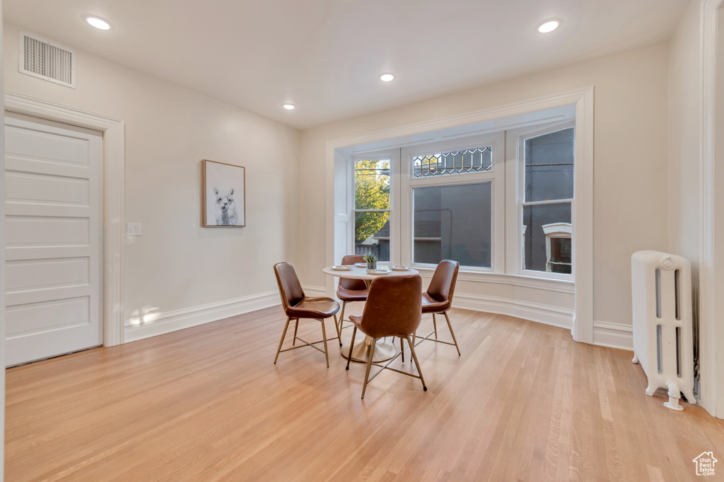 Dining area featuring light hardwood / wood-style flooring and radiator heating unit