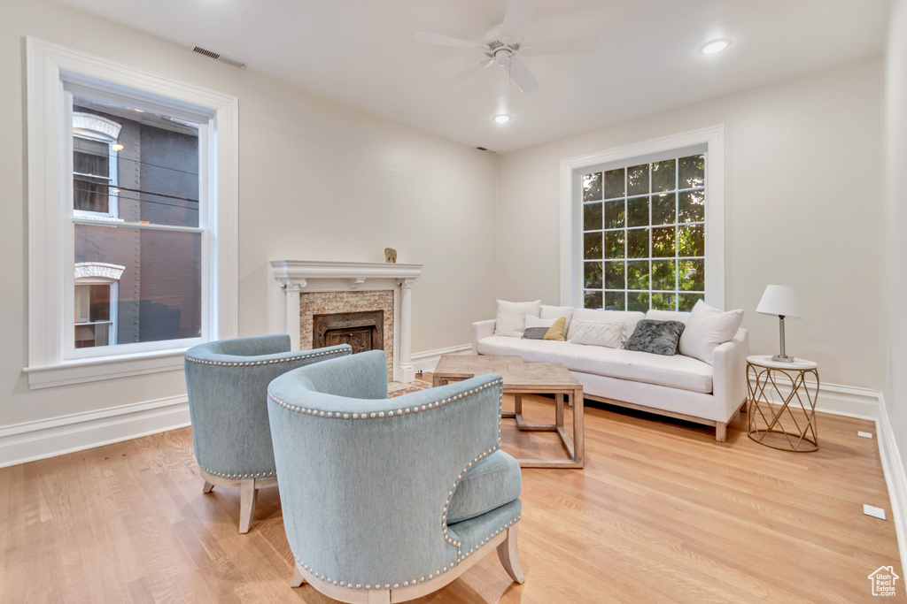 Living room with ceiling fan and hardwood / wood-style floors