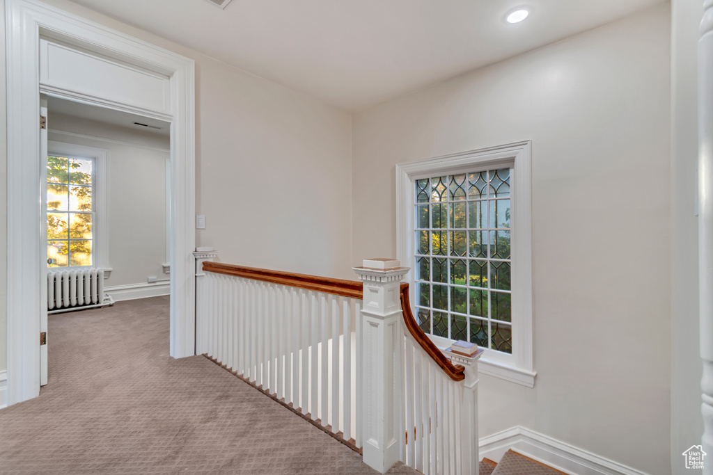 Hall featuring light carpet and radiator heating unit