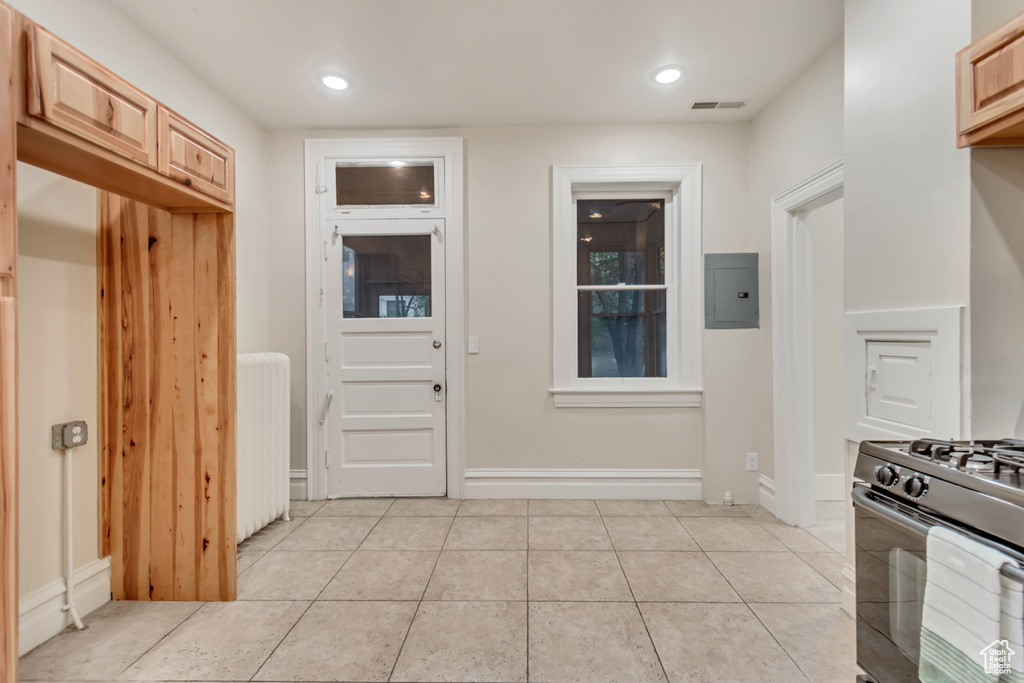 Interior space with radiator, electric panel, and light tile patterned floors