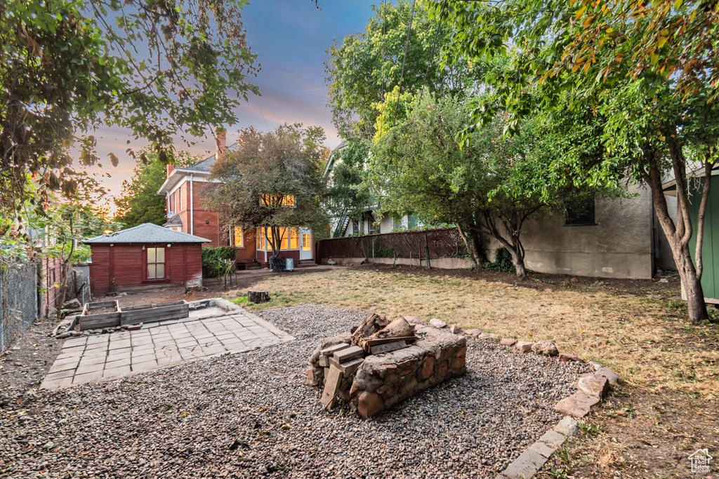 Yard at dusk with a patio area and an outdoor fire pit