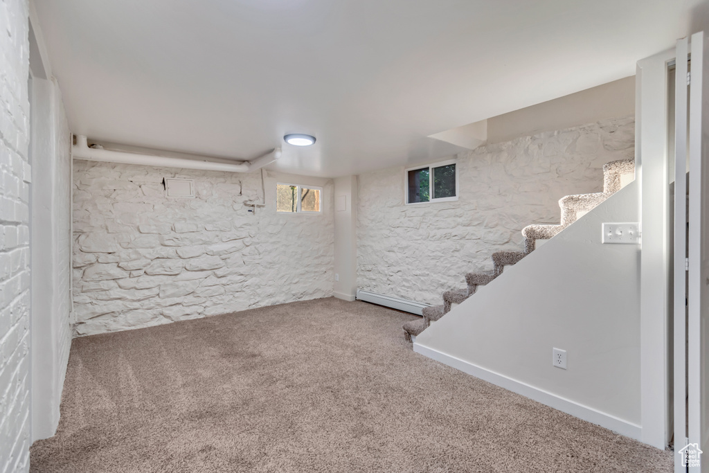 Basement with baseboard heating and carpet flooring