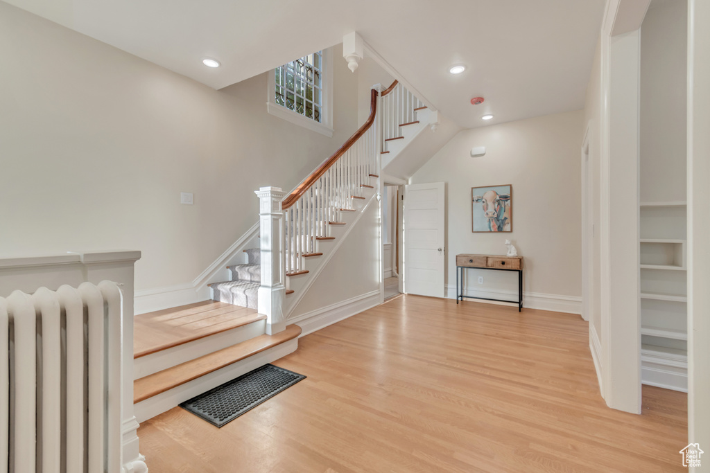 Entryway featuring radiator heating unit and hardwood / wood-style flooring