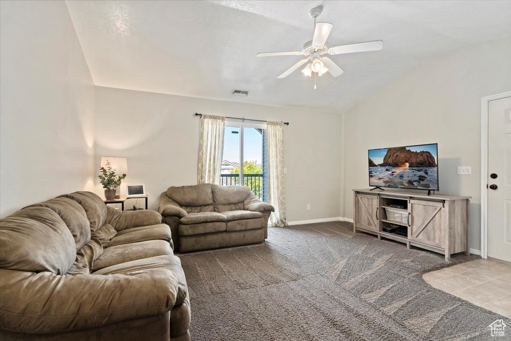 Carpeted living room featuring vaulted ceiling and ceiling fan