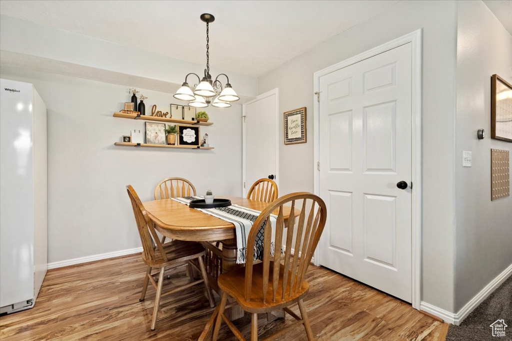 Dining area with a notable chandelier and wood-type flooring