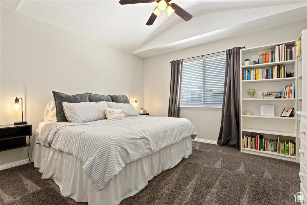 Carpeted bedroom with vaulted ceiling and ceiling fan