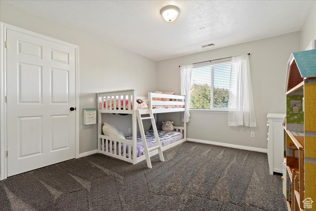 Carpeted bedroom with a textured ceiling