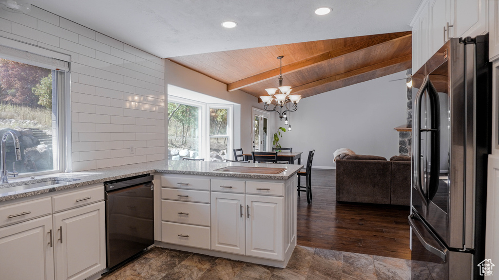 Kitchen featuring decorative light fixtures, kitchen peninsula, black dishwasher, and white cabinets