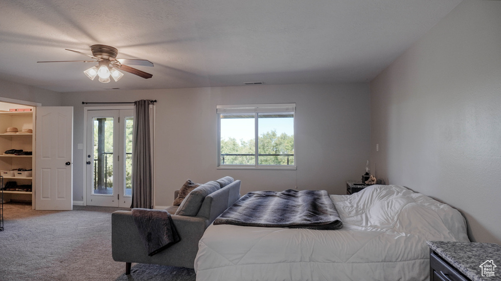 Carpeted bedroom with access to outside and ceiling fan