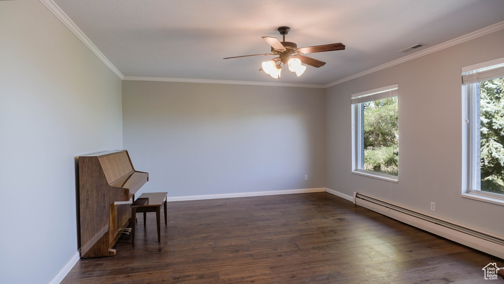 Unfurnished room featuring a baseboard heating unit, ceiling fan, and plenty of natural light