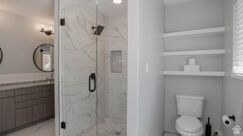 Bathroom with vanity, toilet, and a shower with shower door