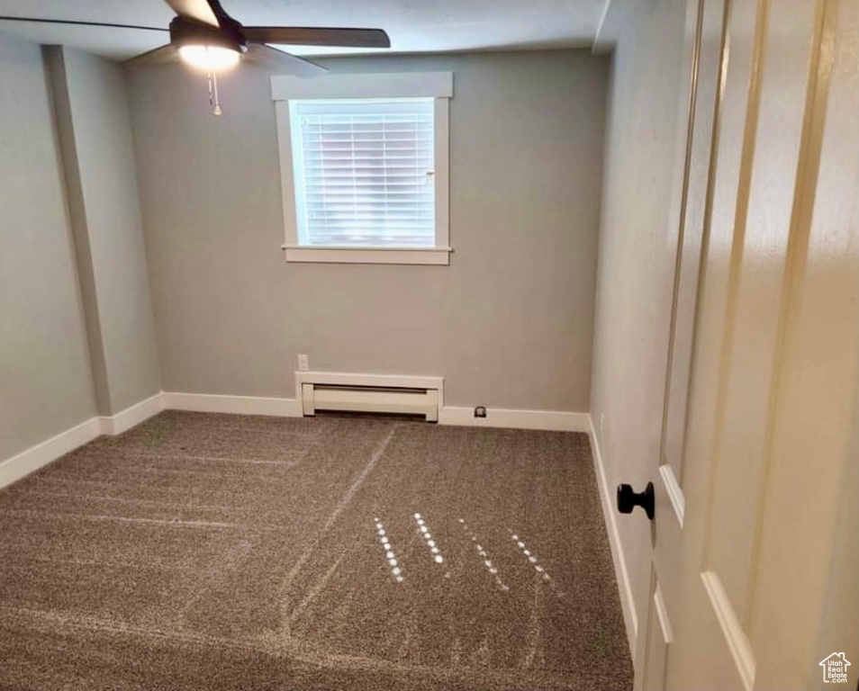 Empty room with a baseboard radiator, carpet, and ceiling fan