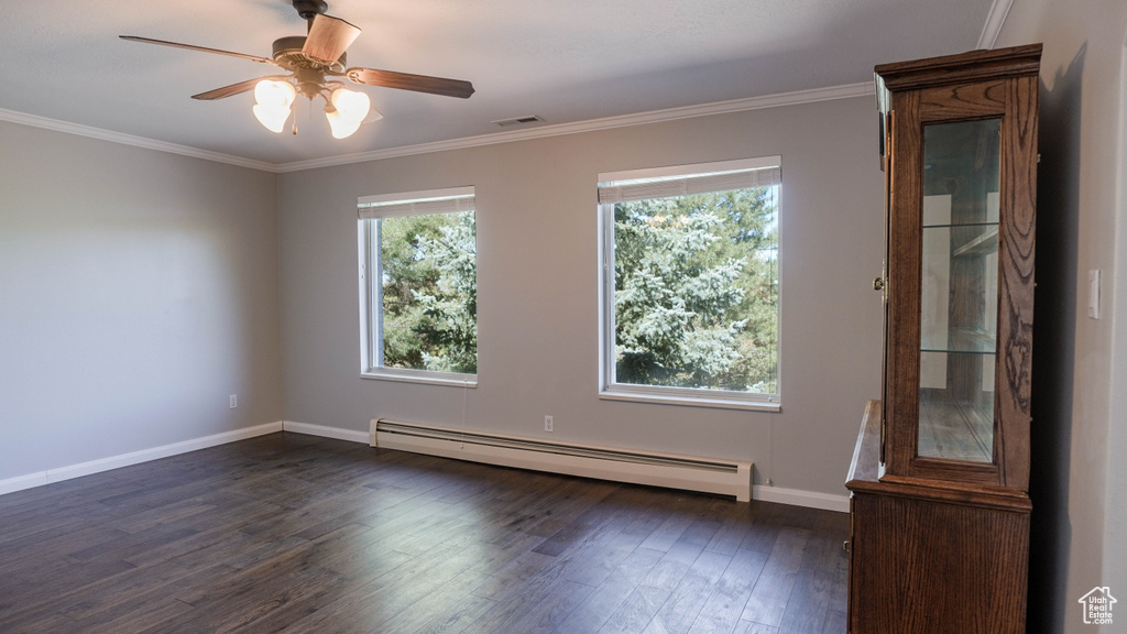 Unfurnished room with a baseboard heating unit, ceiling fan, crown molding, and dark hardwood / wood-style flooring