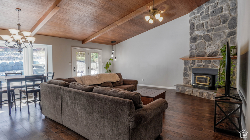 Living room featuring vaulted ceiling with beams, ceiling fan with notable chandelier, a fireplace, and dark hardwood / wood-style floors