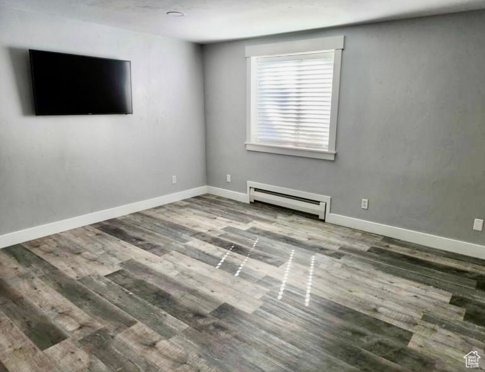 Unfurnished room with hardwood / wood-style flooring and a baseboard radiator