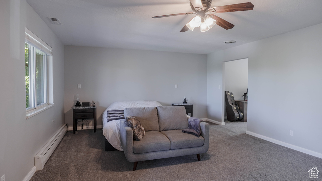 Carpeted bedroom with a baseboard heating unit and ceiling fan