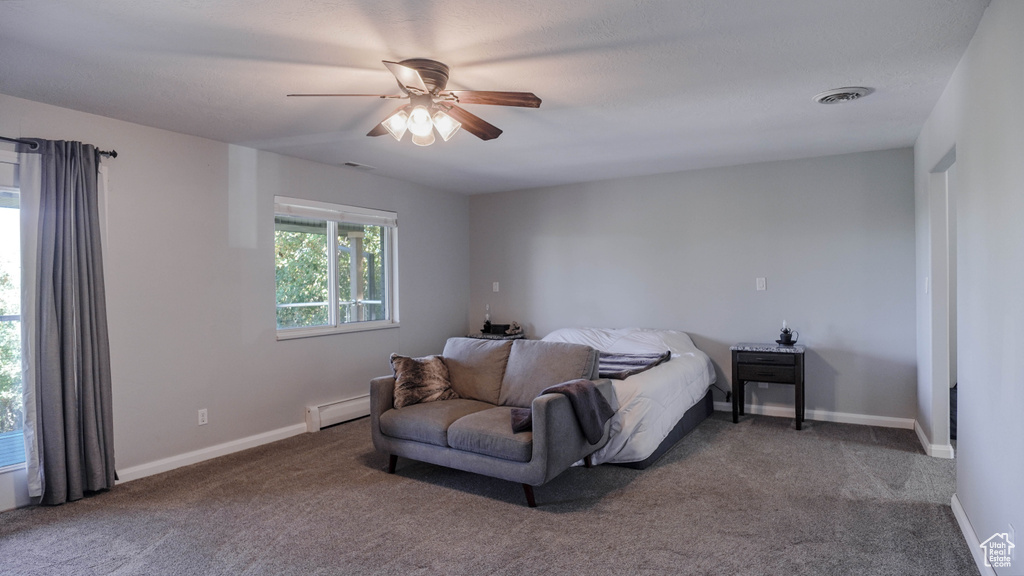 Carpeted bedroom featuring ceiling fan and a baseboard radiator