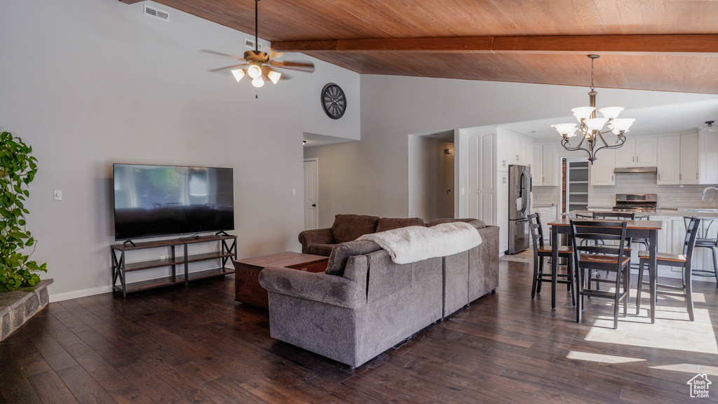 Living room with wooden ceiling, ceiling fan with notable chandelier, dark hardwood / wood-style floors, and high vaulted ceiling