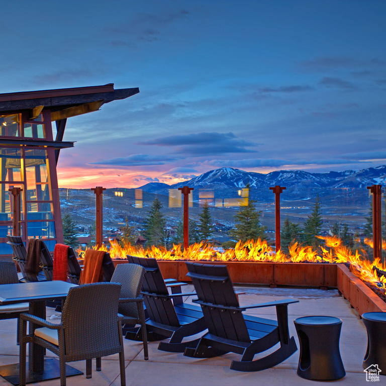 Patio terrace at dusk with a mountain view and a fire pit