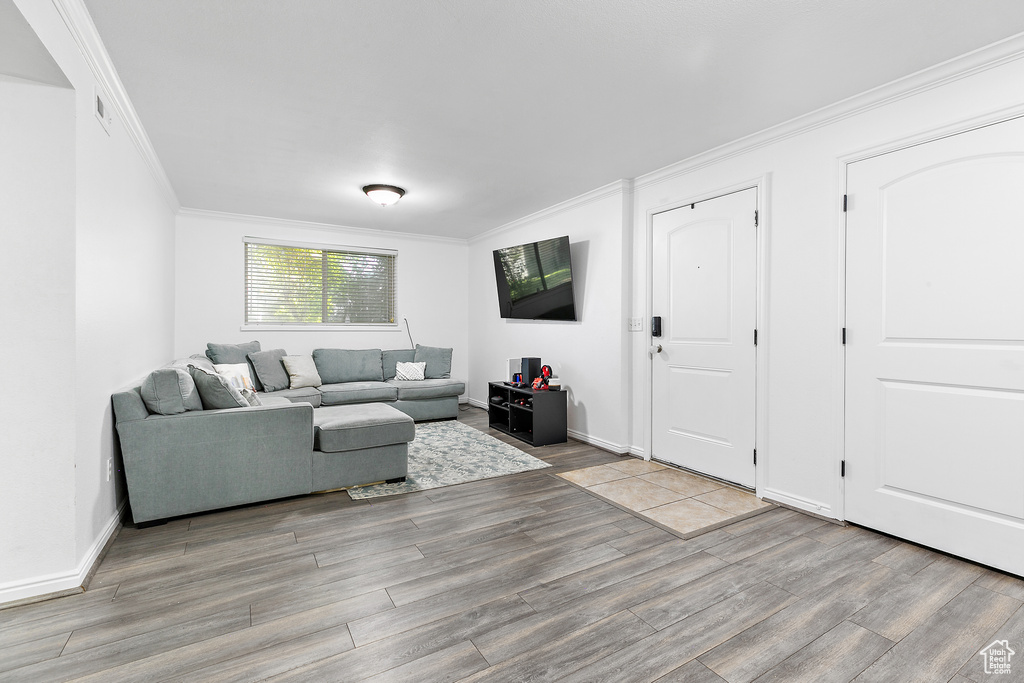 Living room with wood-type flooring and ornamental molding