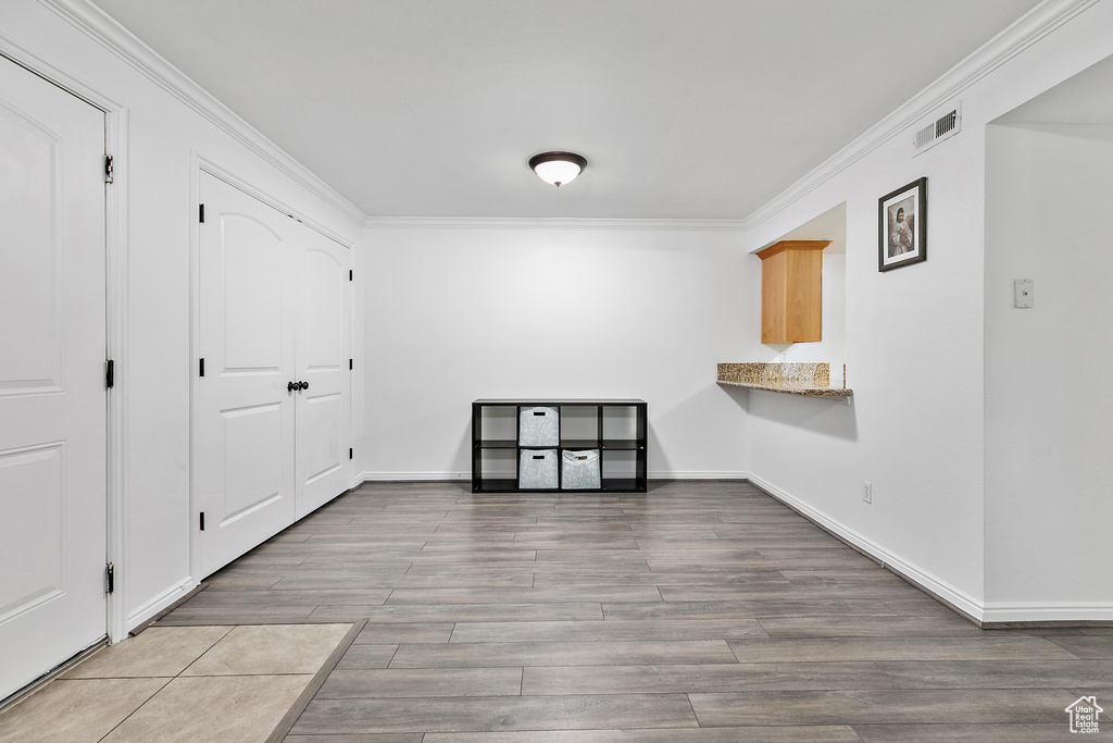 Unfurnished room with hardwood / wood-style flooring and crown molding