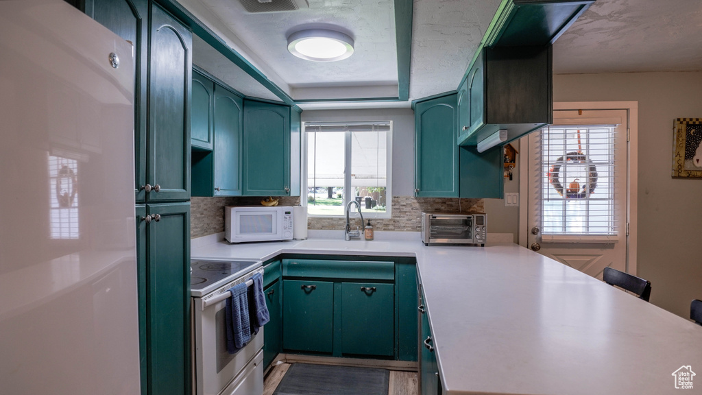 Kitchen with stainless steel stove, sink, and backsplash