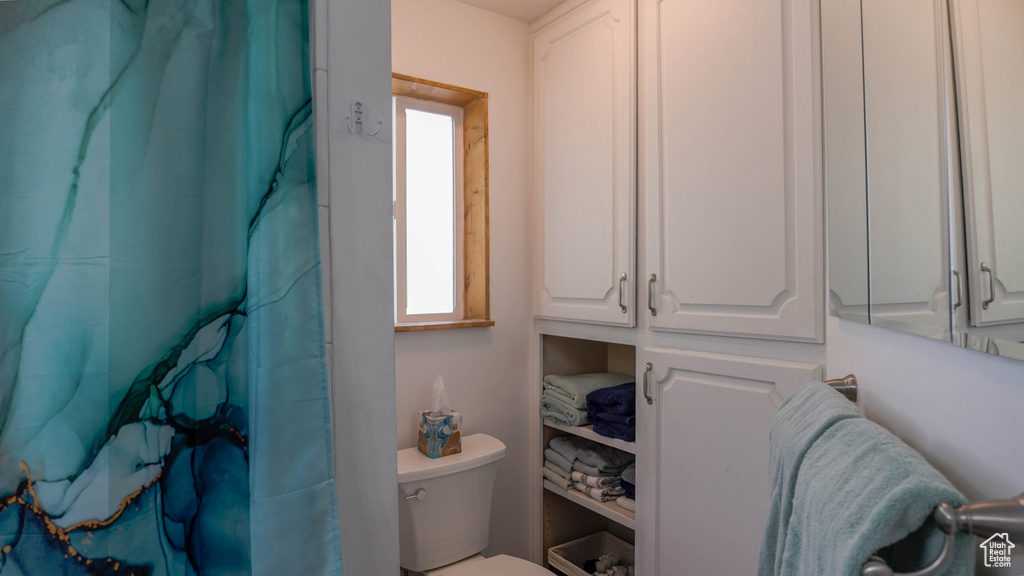 Bathroom featuring toilet and a shower with curtain