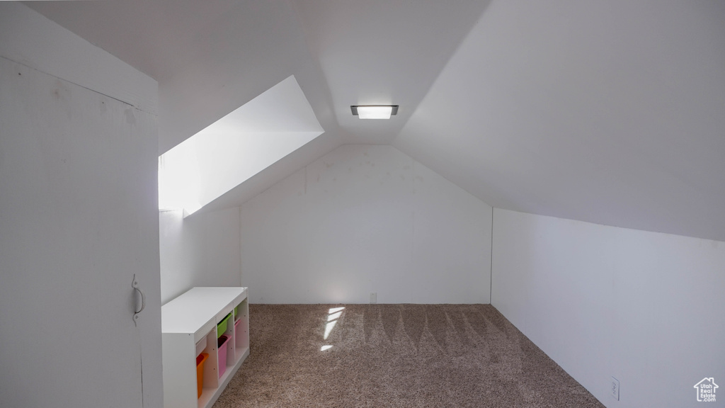 Bonus room featuring vaulted ceiling and carpet flooring