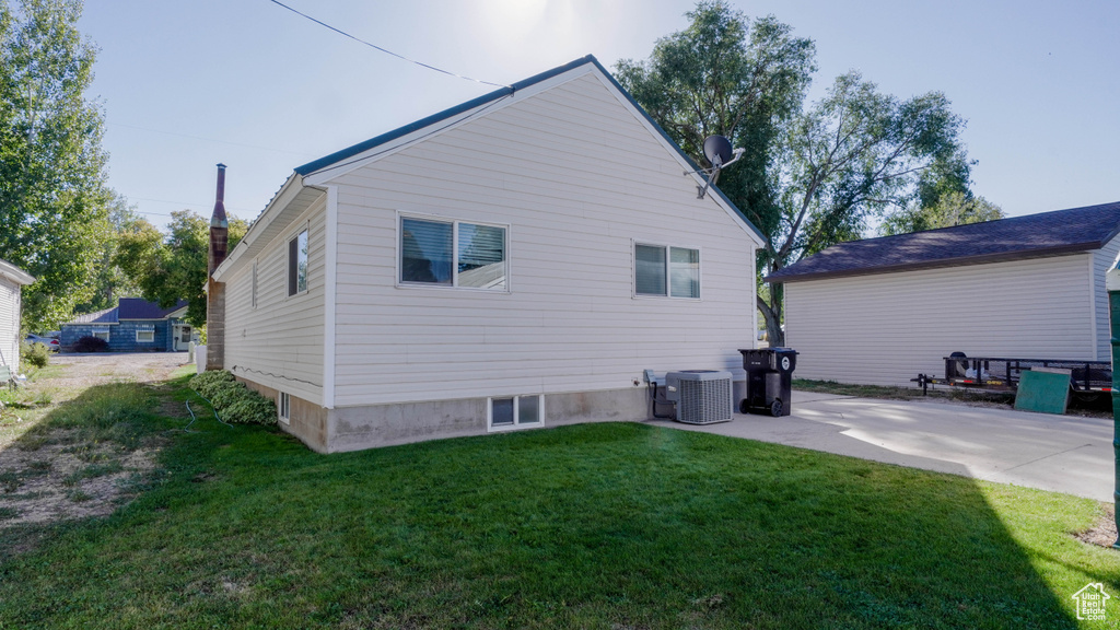 Back of house with a patio, a yard, and central AC