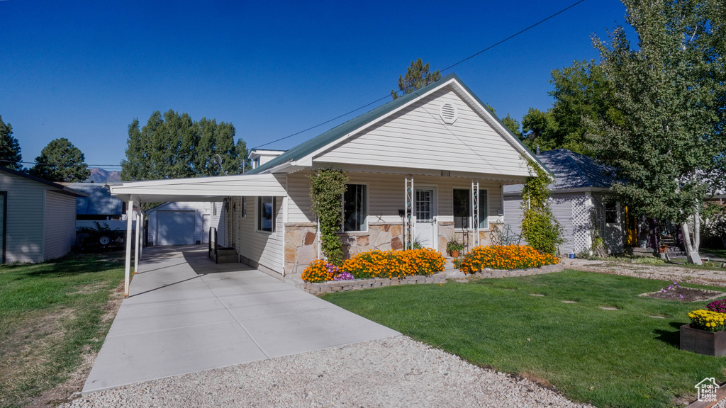 Bungalow featuring a carport, a front yard, and covered porch