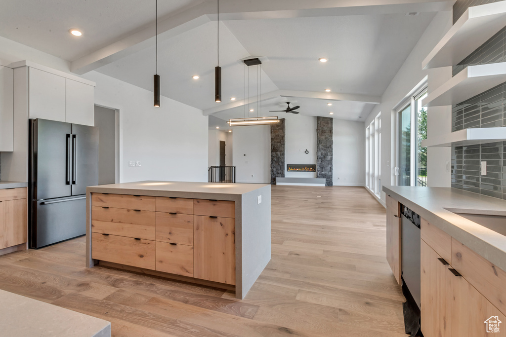 Kitchen featuring stainless steel appliances, ceiling fan, light wood-type flooring, and a fireplace