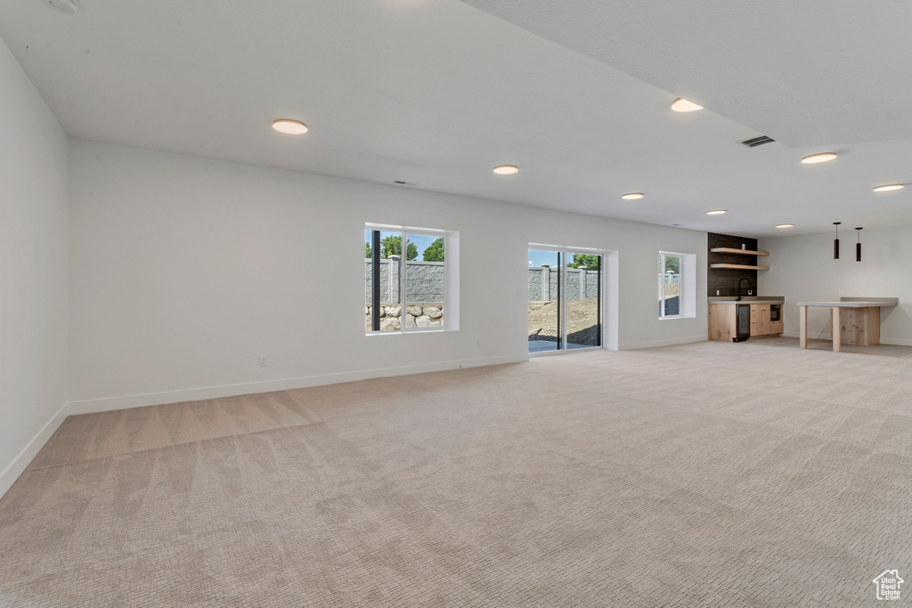 Unfurnished living room featuring light colored carpet