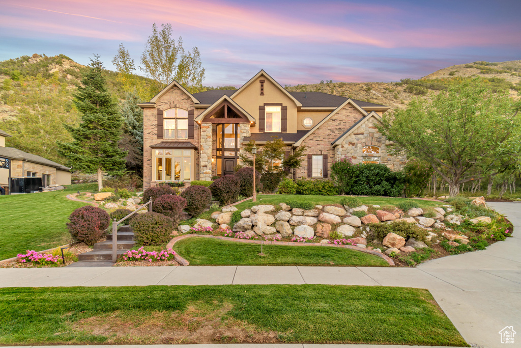 View of front of home featuring a lawn and a mountain view