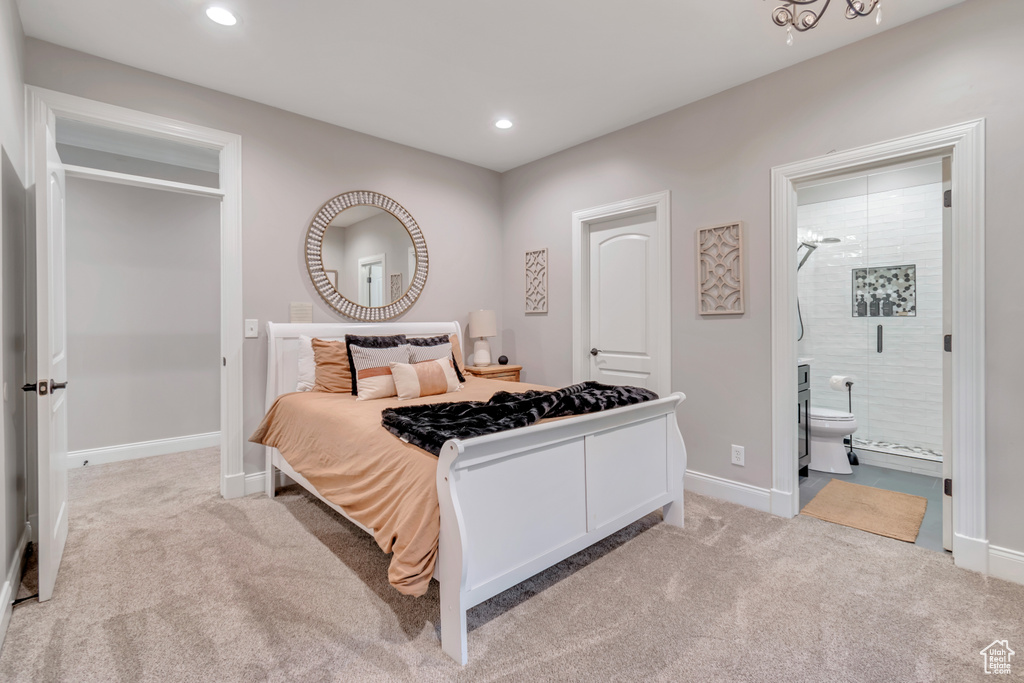 Carpeted bedroom featuring ensuite bathroom