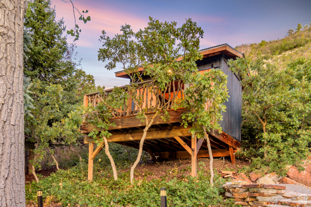 Back house at dusk with a wooden deck