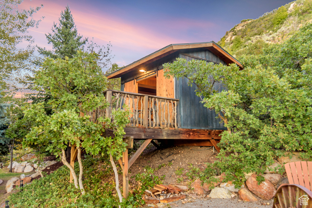 Back house at dusk featuring a deck