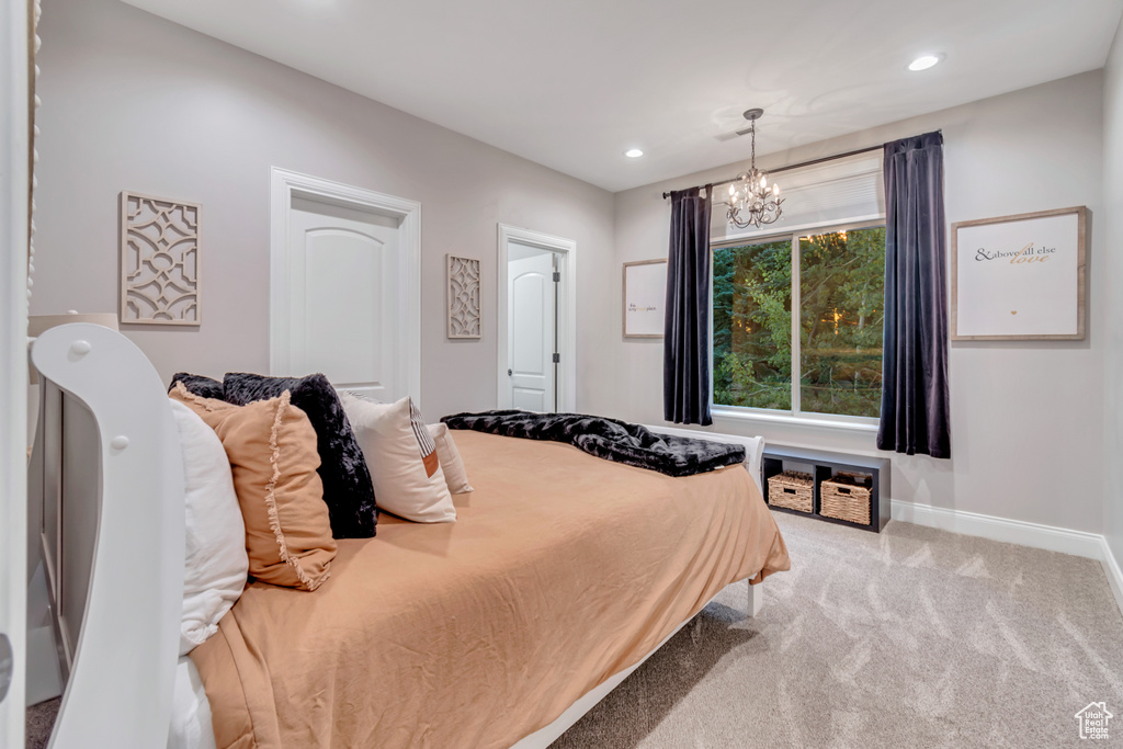 Carpeted bedroom with a notable chandelier