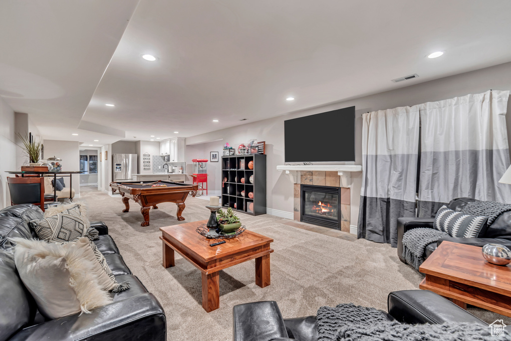 Living room with light carpet, a tiled fireplace, and pool table