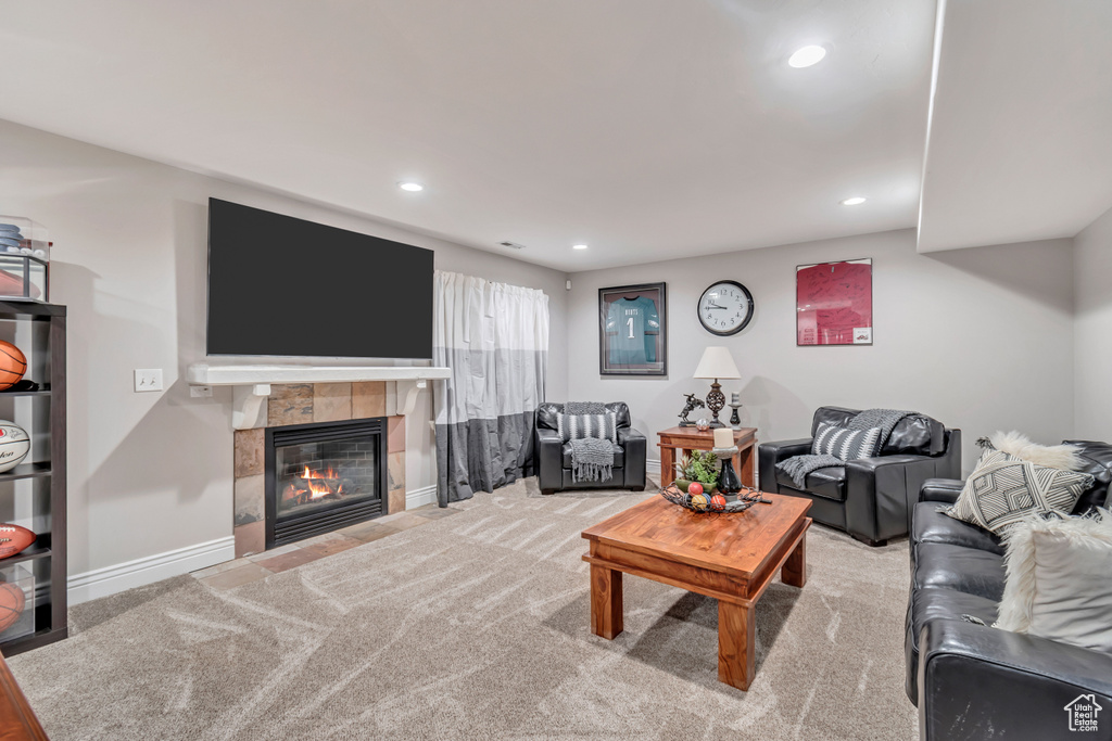 Living room featuring carpet floors and a tiled fireplace