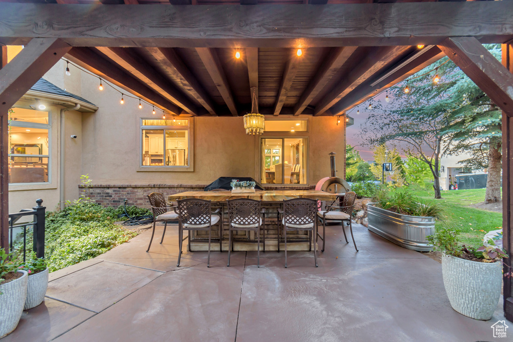 Patio terrace at dusk featuring an outdoor kitchen