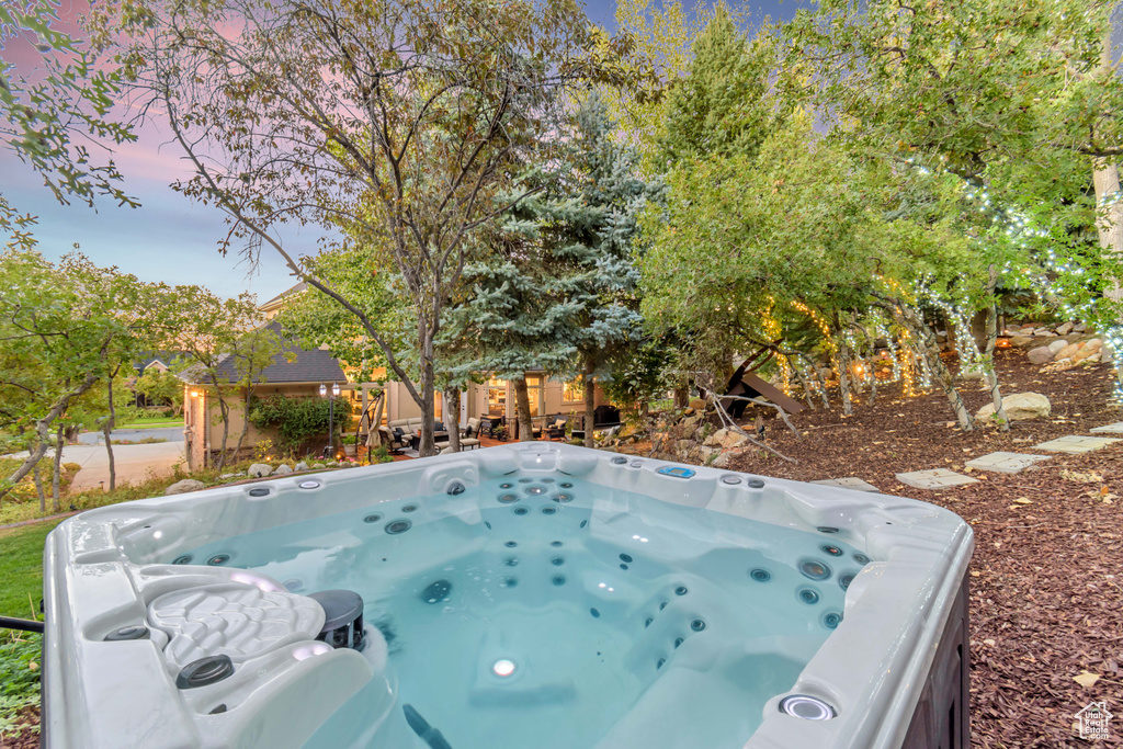 Pool at dusk with a hot tub