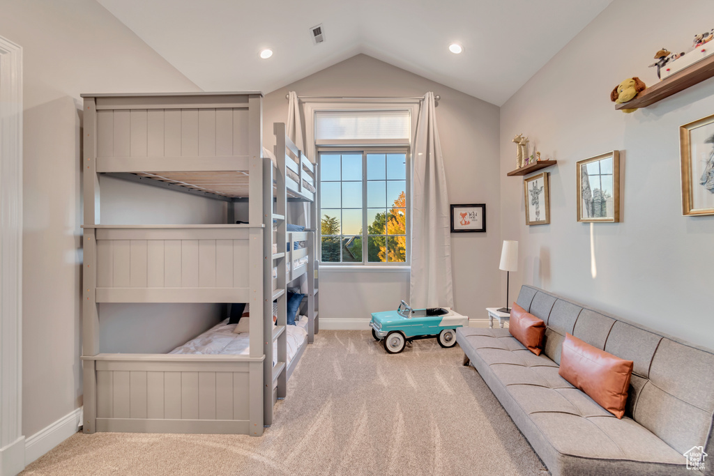 Bedroom with carpet flooring and vaulted ceiling