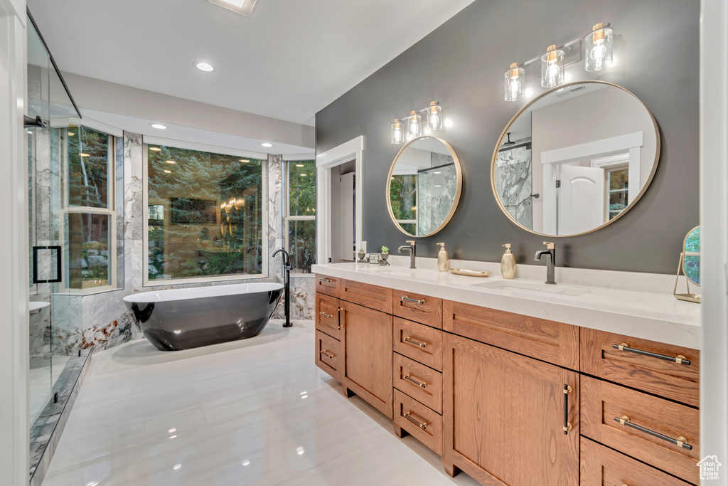 Bathroom with tile patterned floors, a bath, and vanity